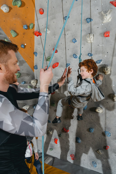 Boy on climbing wall high-fiving father Stock photo © LightFieldStudios