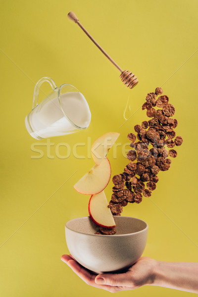 cropped shot of woman holding bowl with levitating breakfast Stock photo © LightFieldStudios