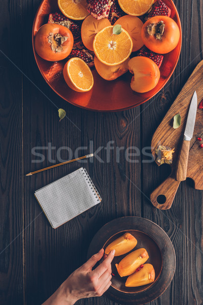 Afbeelding vrouw stuk persimmon hand Stockfoto © LightFieldStudios