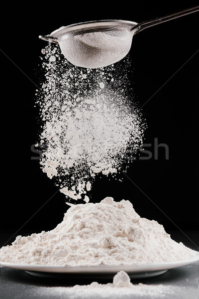 flour falling from sieve on pile isolated on black Stock photo © LightFieldStudios