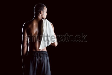 back view of african sporty man with towel on shoulder on black Stock photo © LightFieldStudios