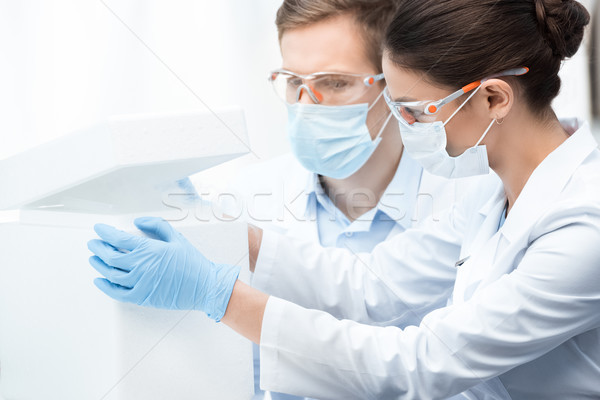 Young professional chemists in protective workwear making experiment with liquid nitrogen  Stock photo © LightFieldStudios