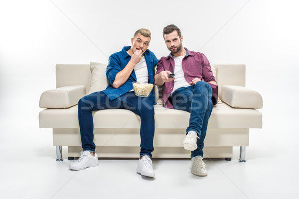 Férfi barátok néz tv ül kanapé Stock fotó © LightFieldStudios