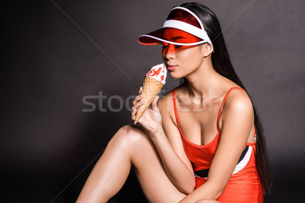 woman in swimsuit and visor eating ice-cream Stock photo © LightFieldStudios