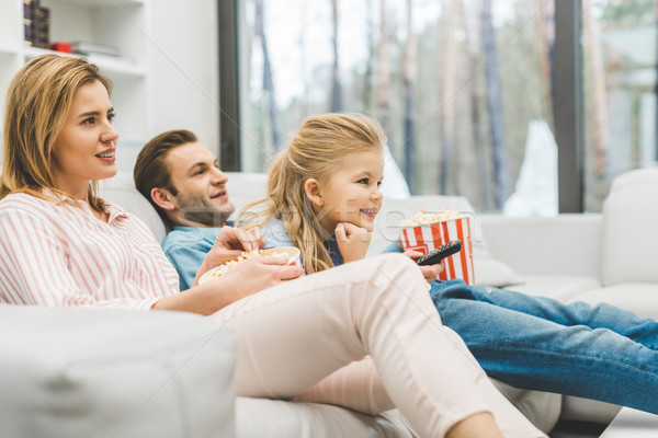 side view of family with popcorn watching film together at home Stock photo © LightFieldStudios