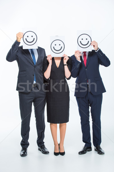 üzletemberek tart kártyák három emotikonok fehér Stock fotó © LightFieldStudios