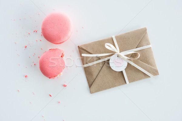 Top view of decorative kraft envelope with bow and pink macarons isolated on white, wedding invitati Stock photo © LightFieldStudios