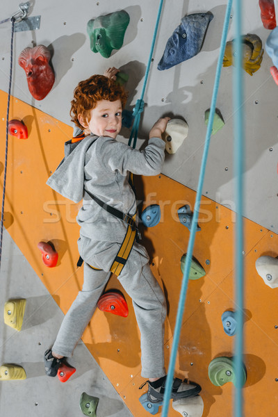 Little boy climbing wall with grips Stock photo © LightFieldStudios