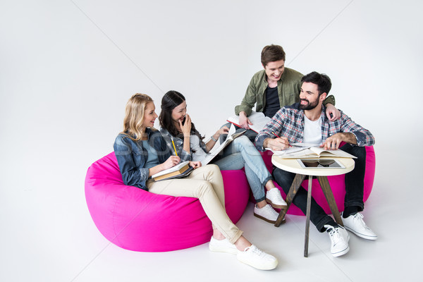 students sitting on beanbag chairs and studying in studio on white  Stock photo © LightFieldStudios