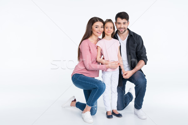 Happy young family with one child smiling at camera on white  Stock photo © LightFieldStudios