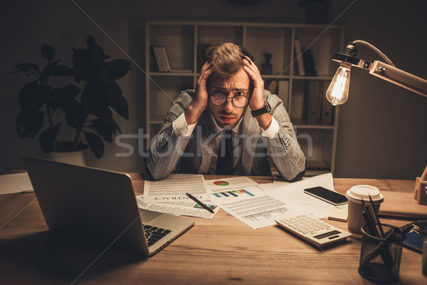 Túlhajszolt üzletember papírmunka fiatal iroda késő Stock fotó © LightFieldStudios
