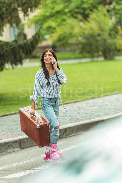 girl in roller skates with smartphone and suitcase Stock photo © LightFieldStudios