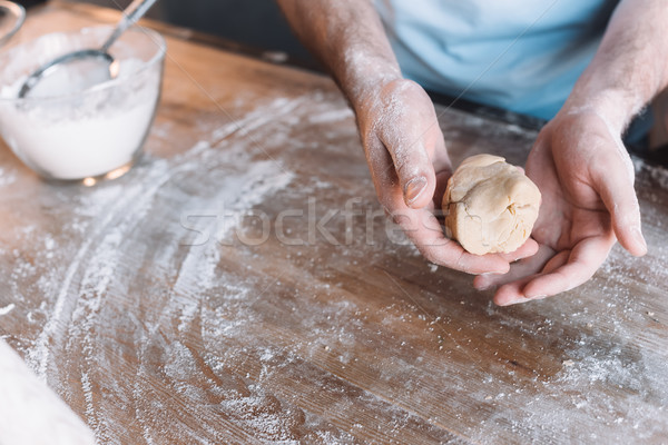 'Close-up partial view of man kneading dough at wooden table Stock photo © LightFieldStudios