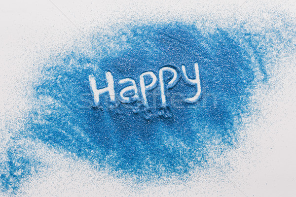 top view of happy sign made of blue sand on white surface Stock photo © LightFieldStudios