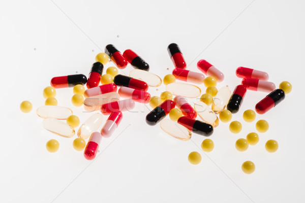 Pile of colorful medical pills on white, medicine and healthcare concept Stock photo © LightFieldStudios