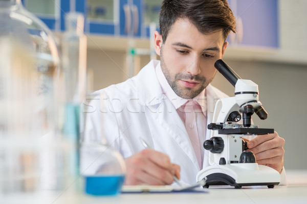 Stock foto: Konzentrierter · Mann · Wissenschaftler · arbeiten · Mikroskop · Notizen