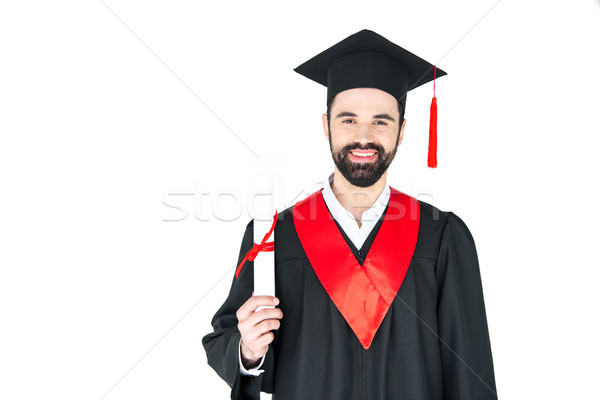 Happy young man in graduation hat holding diploma and looking at camera Stock photo © LightFieldStudios