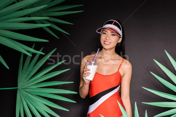 woman in swimsuit and visor drinking milkshake Stock photo © LightFieldStudios
