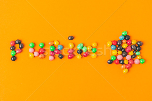 top view of purim lettering made of candies and star isolated on orange Stock photo © LightFieldStudios