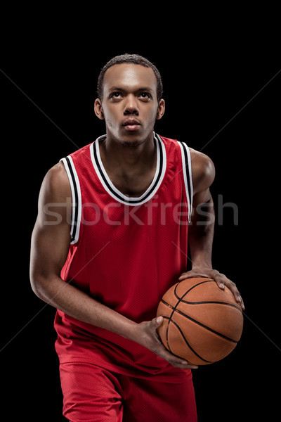 Young sportsman in uniform playing basketball with ball on black  Stock photo © LightFieldStudios