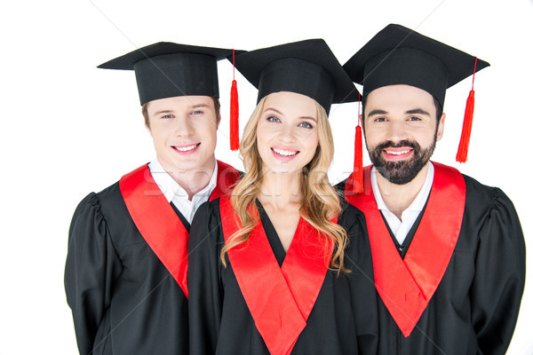 Happy students in mortarboards and mantles smiling at camera Stock photo © LightFieldStudios