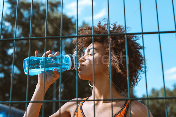 fit african-american woman drinking water Stock photo © LightFieldStudios