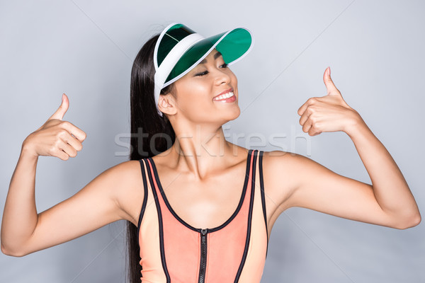 woman in visor showing thumbs up Stock photo © LightFieldStudios