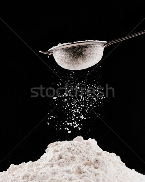 flour falling from sieve on pile for pastry isolated on black Stock photo © LightFieldStudios