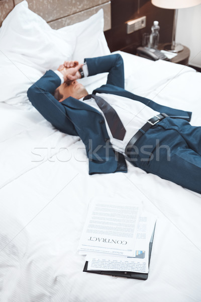 Exhausted businessman lying on bed Stock photo © LightFieldStudios