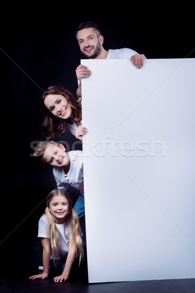 Happy family holding blank card Stock photo © LightFieldStudios
