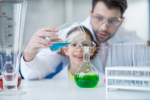 Teacher and student scientists in protective glasses working in chemical lab Stock photo © LightFieldStudios