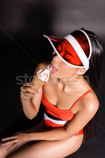 woman in swimsuit and visor eating ice-cream Stock photo © LightFieldStudios