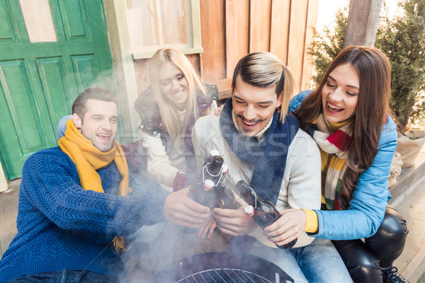 high angle view of cheerful friends sitting on porch with beer on barbeque Stock photo © LightFieldStudios