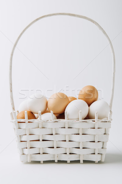 white and brown eggs laying in wicker basket on white background  Stock photo © LightFieldStudios