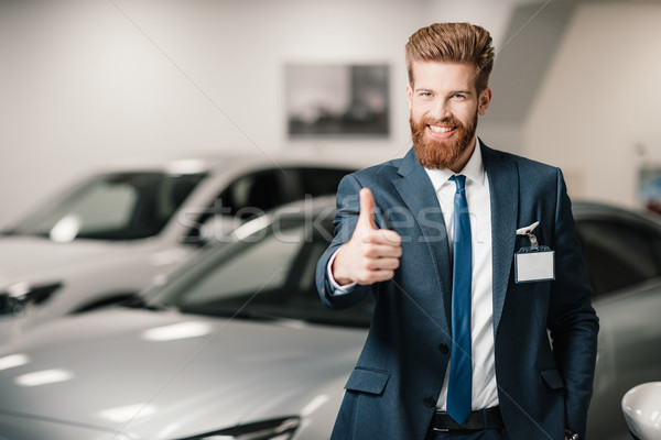 salesman in suit showing thumb up and looking at camera in dealership salon   Stock photo © LightFieldStudios