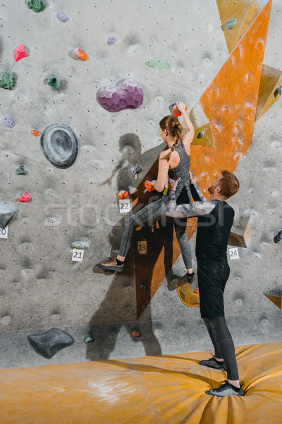 young woman climbing wall with grips Stock photo © LightFieldStudios