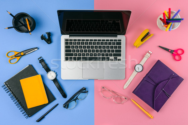 top view of laptop with blank screen, eyeglasses, wristwatches and notebooks divided at male and fem Stock photo © LightFieldStudios