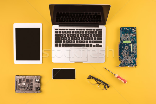 top view of digital devices with black screens and motherboard and hardware on yellow Stock photo © LightFieldStudios