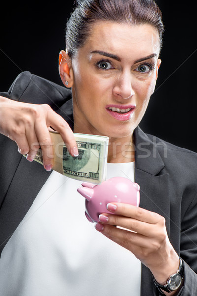 Businesswoman holding piggybank Stock photo © LightFieldStudios
