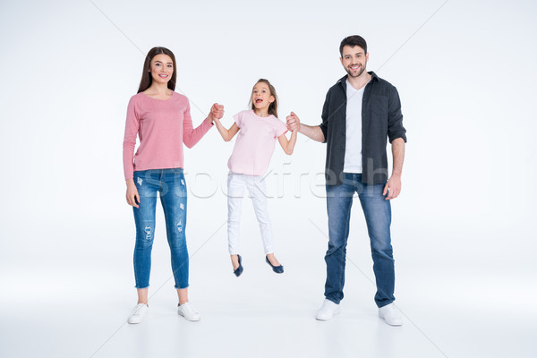 Happy young family with one child holding hands and smiling at camera  Stock photo © LightFieldStudios