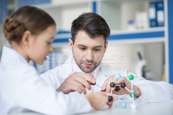 Concentrated man teacher and girl student scientists working with molecular model in lab Stock photo © LightFieldStudios