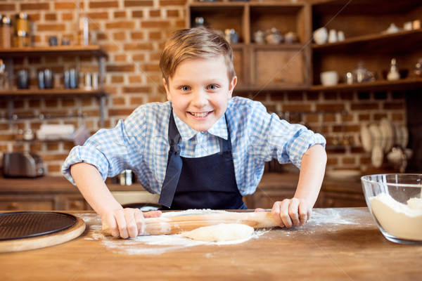 Stock photo: little boy making pizza dough on wooden tabletop in kitchen 