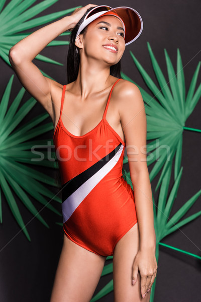 Smiling woman in orange swimsuit and visor Stock photo © LightFieldStudios