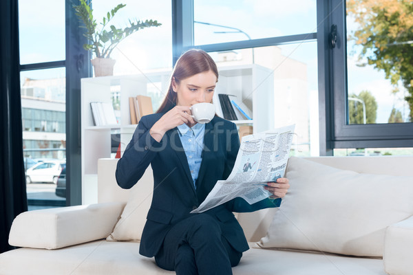 Stock photo: businesswoman with newspaper drinking coffee