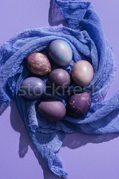 top view of traditional painted eggs on gauze, on purple Stock photo © LightFieldStudios