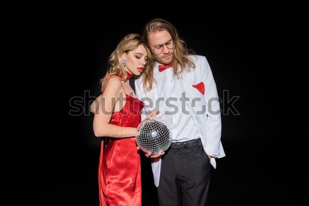 Stock photo: Side view of man kissing woman with heart in hand on black, international women's day concept