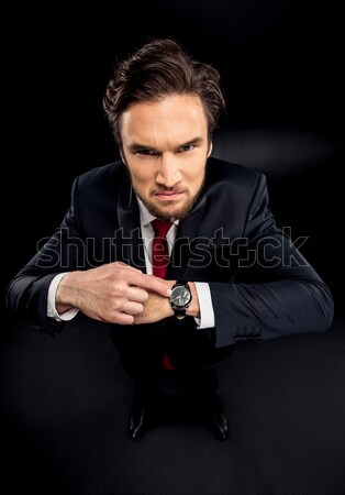 Businessman pointing at wristwatch Stock photo © LightFieldStudios