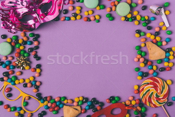 top view of arranged masquerade masks, candies and cookies isolated on purple Stock photo © LightFieldStudios