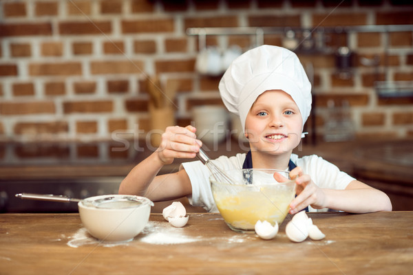 little boy in chef hat making dough for cookies Stock photo © LightFieldStudios
