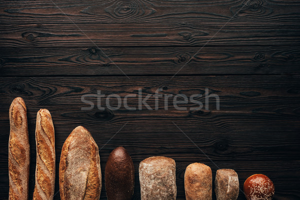 top view of arranged loafs of bread on wooden surface Stock photo © LightFieldStudios
